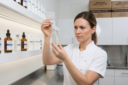 Esthéticienne professionnelle examinant des produits cosméceutiques en gros dans une réserve de salon de beauté moderne